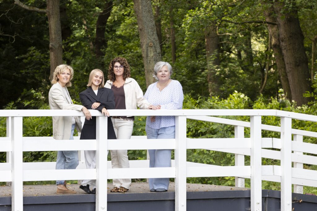Linda, Simone, Iris en Stephanie op een witte houten brug in het bos